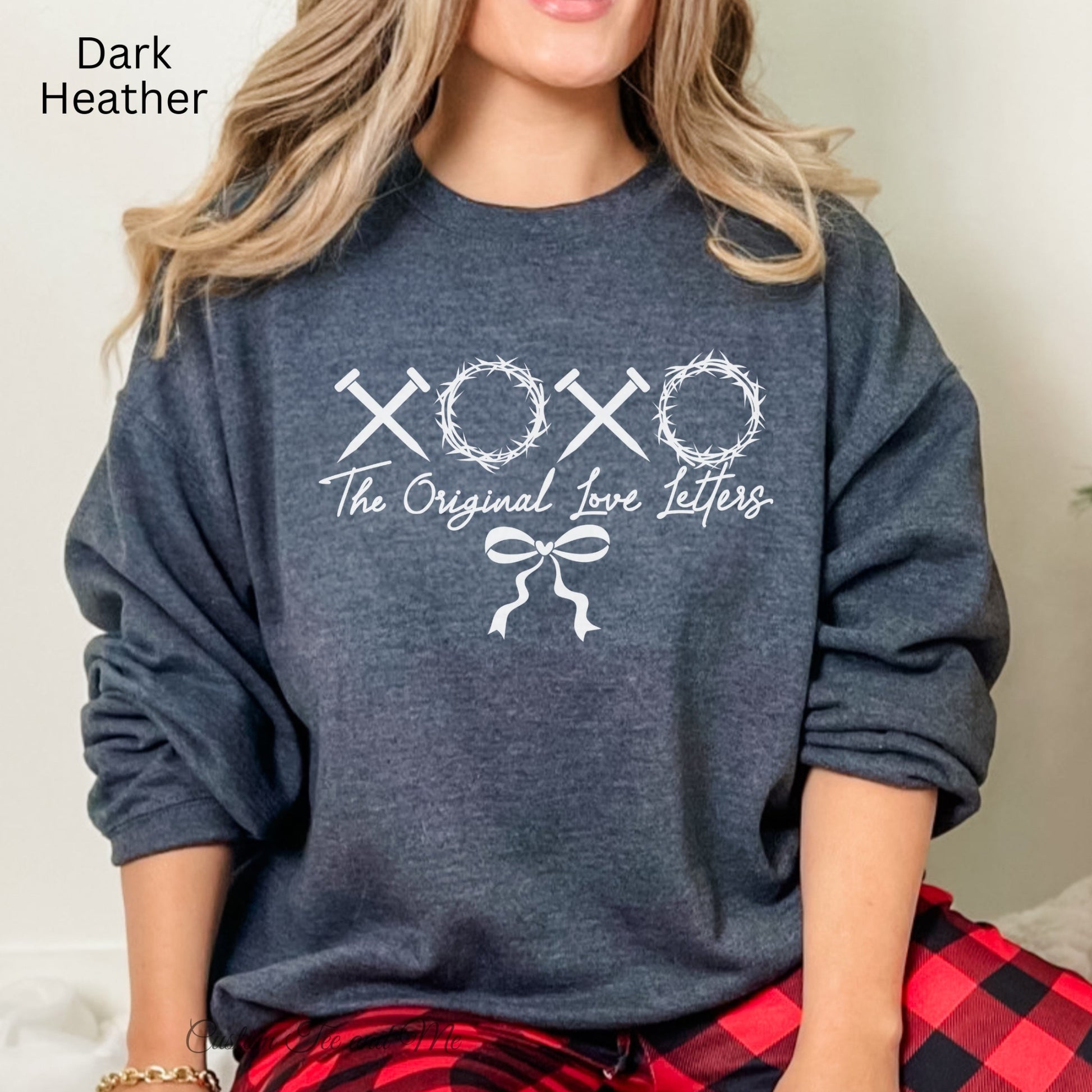 A Christian sweatshirt that has XOXO made of nails and thorns with the inscription "The Original Love Letters".