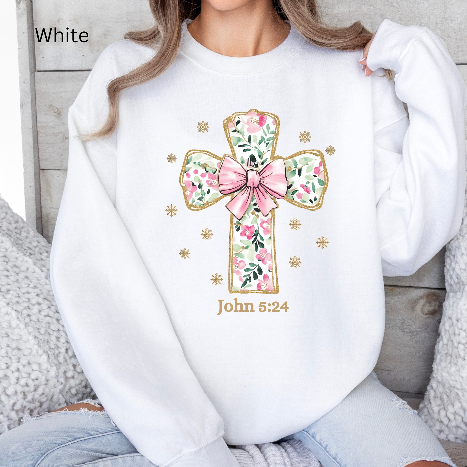 a beautiful flowered Cross with a pink coquette bow outlined in gold on this sweatshirt for her. John 3:24 is noted below.