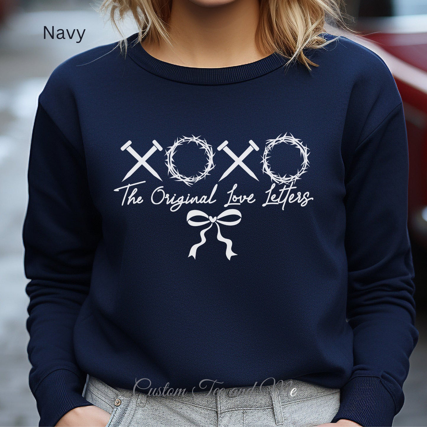 X's made out of spikes and O's made of crowns of thorns make these the original Love letters on this trendy navy sweatshirt.