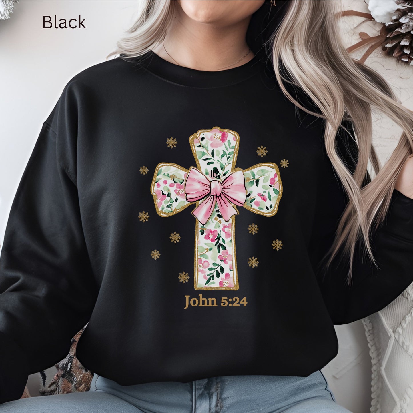 A coquette pink flowered Christian cross with a pink bow and gold outline is trending. John 5:24 is noted under the large cross. 